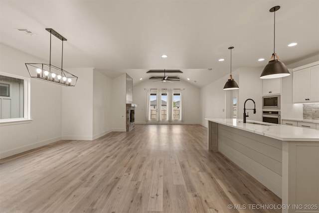2074 E 130th St S, Jenks, OK 74037 - kitchen featuring stainless steel appliances, lofted ceiling, white cabinets, light wood finished floors, and recessed lighting