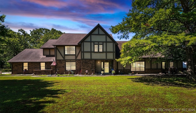 22547 S Dogwood Ct, Claremore, OK 74019 - tudor home featuring a lawn, stucco siding, brick siding, and roof with shingles