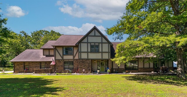 22547 S Dogwood Ct, Claremore, OK 74019 - tudor house featuring a front lawn, brick siding, stucco siding, and roof with shingles