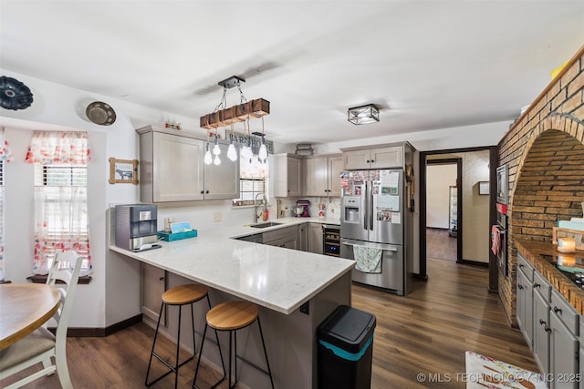 22547 S Dogwood Ct, Claremore, OK 74019 - kitchen featuring stainless steel fridge with ice dispenser, a peninsula, healthy amount of natural light, and a breakfast bar area