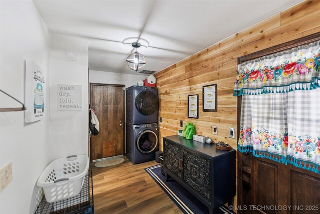 22547 S Dogwood Ct, Claremore, OK 74019 - laundry area with stacked washer / dryer, wooden walls, and wood finished floors