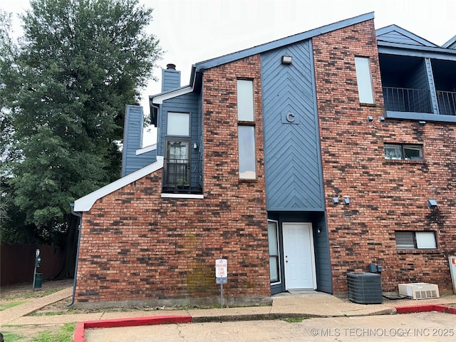 6737 S Peoria Ave Unit C205, Tulsa, OK 74136 - view of front of property with a chimney, a balcony, and brick siding