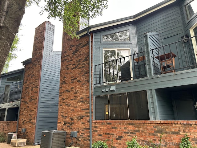 6737 S Peoria Ave Unit C205, Tulsa, OK 74136 - view of side of home featuring a balcony and brick siding