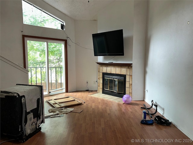 6737 S Peoria Ave Unit C205, Tulsa, OK 74136 - living room featuring a tile fireplace, wood finished floors, and a textured ceiling