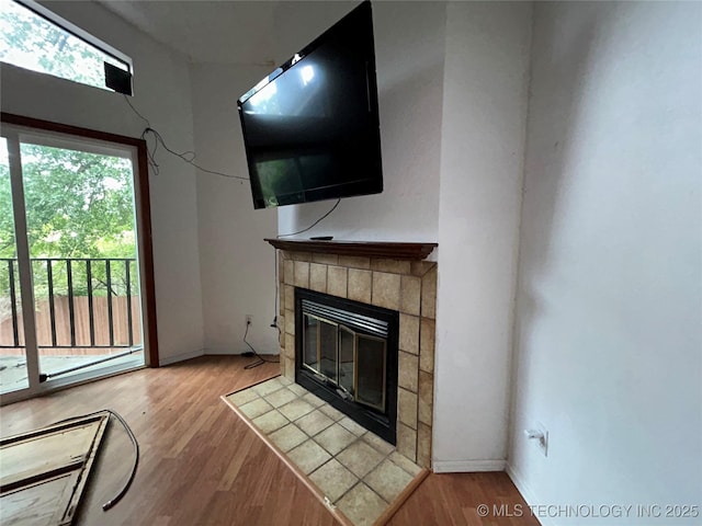 6737 S Peoria Ave Unit C205, Tulsa, OK 74136 - unfurnished living room featuring wood finished floors and a tile fireplace