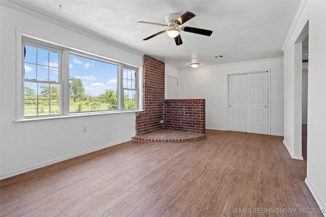 1822 Abner Rd, Overbrook, OK 73453 - unfurnished living room with crown molding, wood finished floors, ceiling fan, baseboards, and a brick fireplace