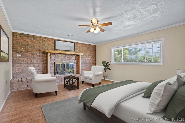 1822 Abner Rd, Overbrook, OK 73453 - bedroom with a textured ceiling, a brick fireplace, wood finished floors, brick wall, and ornamental molding
