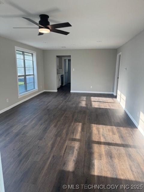 904 W Tishomingo, Madill, OK 73446 - unfurnished living room with baseboards, dark wood-style flooring, and ceiling fan