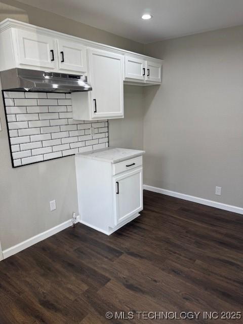 904 W Tishomingo, Madill, OK 73446 - kitchen with under cabinet range hood, baseboards, dark wood finished floors, white cabinets, and recessed lighting