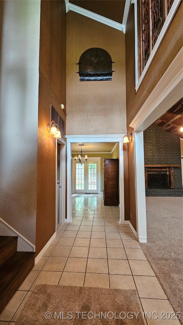 6401 S 86th E Ave, Tulsa, OK 74133 - hallway featuring crown molding, a high ceiling, tile patterned flooring, a chandelier, and carpet