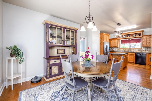 3127 Pleasant Hill Rd, Caddo, OK 74729 - dining room featuring light wood-style flooring, a chandelier, and baseboards