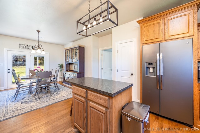 3127 Pleasant Hill Rd, Caddo, OK 74729 - kitchen featuring stainless steel fridge with ice dispenser, a chandelier, light wood-style flooring, and dark countertops