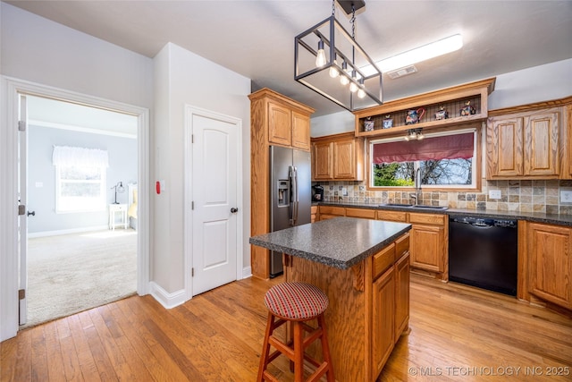 3127 Pleasant Hill Rd, Caddo, OK 74729 - kitchen with black dishwasher, stainless steel refrigerator with ice dispenser, a sink, a center island, and dark countertops
