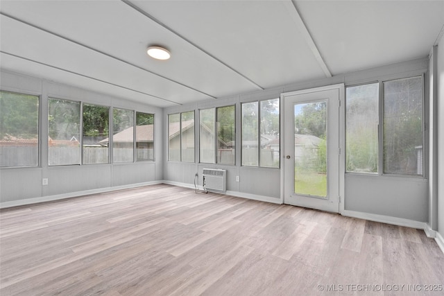 328 I St SW, Ardmore, OK 73401 - unfurnished sunroom featuring wood finished floors, a wall mounted AC, plenty of natural light, and a wooden deck