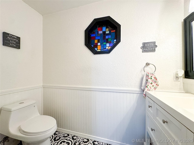 8722 E 74th Pl, Tulsa, OK 74133 - bathroom featuring vanity, a wainscoted wall, and toilet