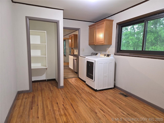 14202 E 492nd Rd, Claremore, OK 74019 - laundry room with cabinet space, washing machine and clothes dryer, light wood-style floors, and ornamental molding