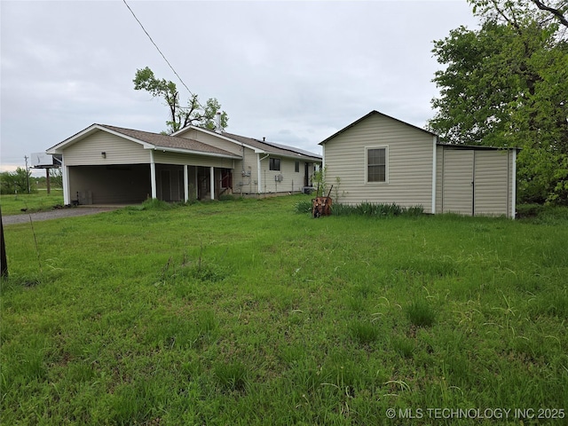 14202 E 492nd Rd, Claremore, OK 74019 - back of house featuring driveway, a yard, and an attached carport