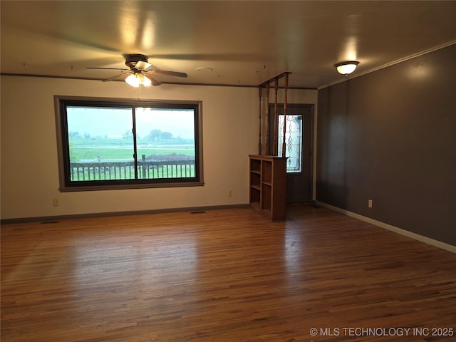14202 E 492nd Rd, Claremore, OK 74019 - unfurnished room featuring plenty of natural light, a ceiling fan, wood finished floors, and crown molding