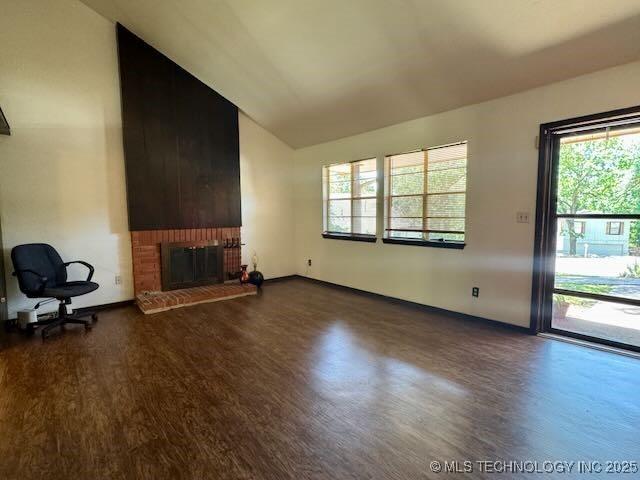 1822 N Xenophon Ave, Tulsa, OK 74127 - unfurnished living room featuring dark wood-style floors, a brick fireplace, and high vaulted ceiling