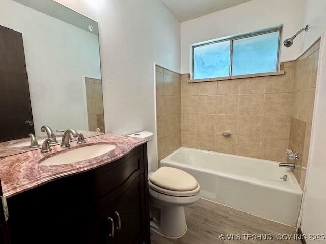1822 N Xenophon Ave, Tulsa, OK 74127 - bathroom featuring vanity, wood finished floors, and shower / washtub combination