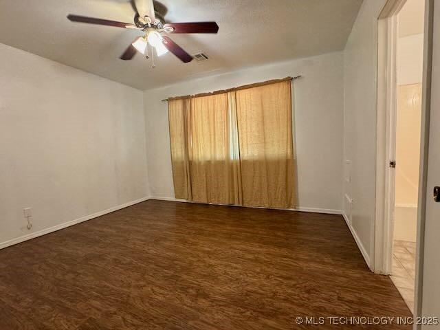 1822 N Xenophon Ave, Tulsa, OK 74127 - unfurnished room featuring a ceiling fan and dark wood-style flooring