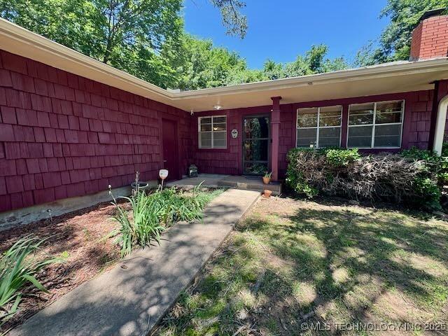 1822 N Xenophon Ave, Tulsa, OK 74127 - doorway to property featuring a chimney