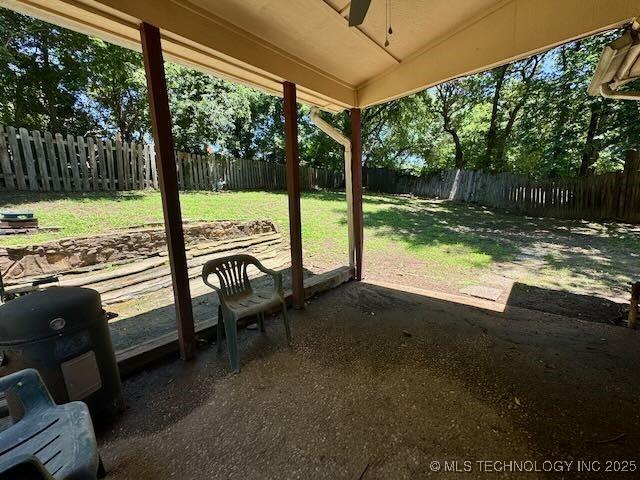 1822 N Xenophon Ave, Tulsa, OK 74127 - fenced backyard featuring a ceiling fan and a patio area