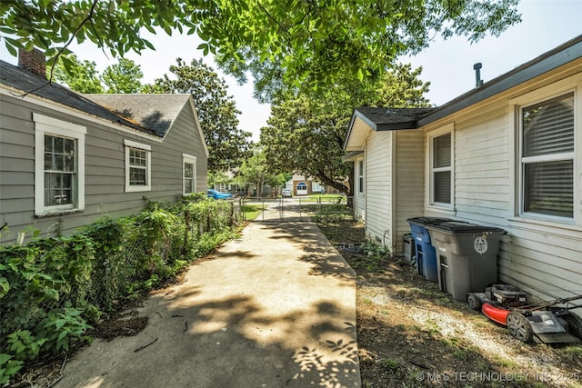 149 N Columbia Pl, Tulsa, OK 74110 - view of home's exterior featuring concrete driveway and roof with shingles