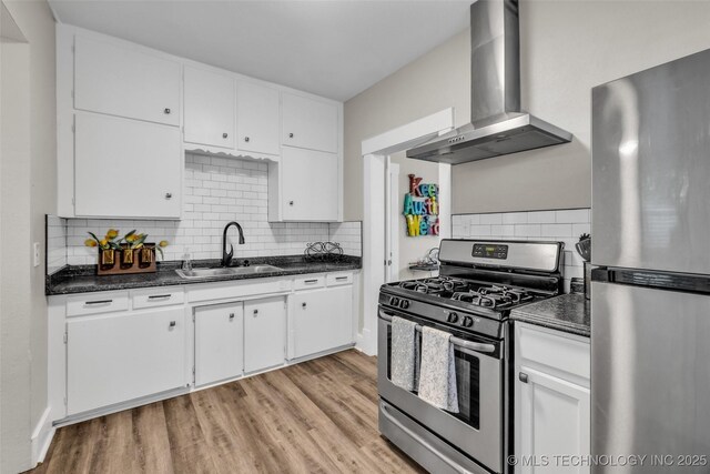 149 N Columbia Pl, Tulsa, OK 74110 - kitchen with appliances with stainless steel finishes, wall chimney exhaust hood, dark countertops, and light wood-type flooring
