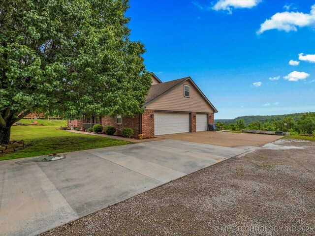 3730 E Mountain Rd, Bartlesville, OK 74003 - view of front of home featuring brick siding, driveway, a front yard, and a garage