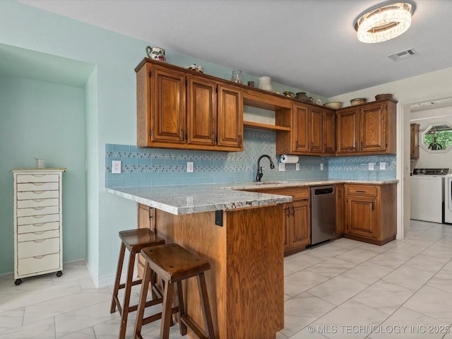 3730 E Mountain Rd, Bartlesville, OK 74003 - kitchen with stainless steel dishwasher, a peninsula, and brown cabinetry