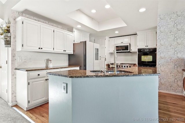 812 N Butternut Ave, Broken Arrow, OK 74012 - kitchen featuring oven, refrigerator with ice dispenser, stainless steel microwave, light wood-type flooring, and wallpapered walls