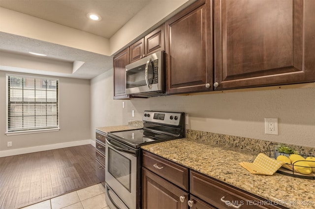 6376 S 80th E Ave Unit 41H, Tulsa, OK 74133 - kitchen with stainless steel appliances, dark brown cabinets, light stone countertops, recessed lighting, and light wood finished floors