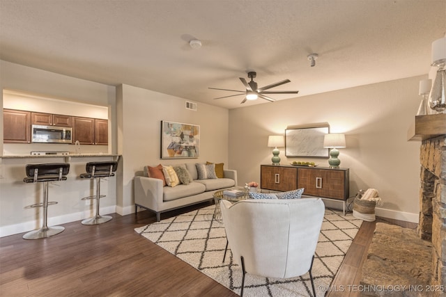 6376 S 80th E Ave Unit 41H, Tulsa, OK 74133 - living room featuring wood finished floors, a ceiling fan, and a fireplace