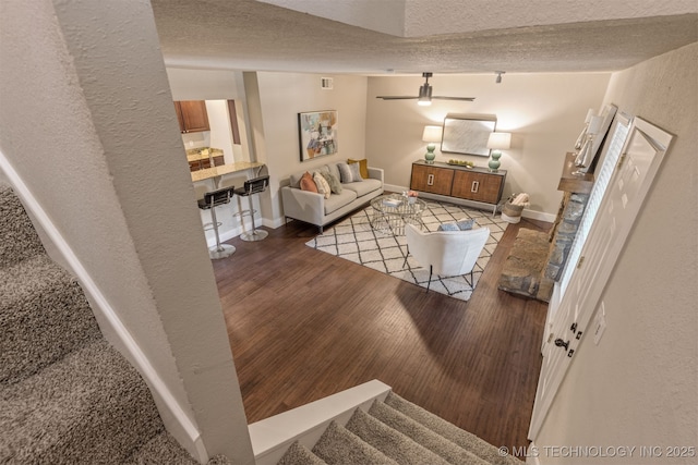 6376 S 80th E Ave Unit 41H, Tulsa, OK 74133 - living area with a textured ceiling, ceiling fan, wood finished floors, and stairway