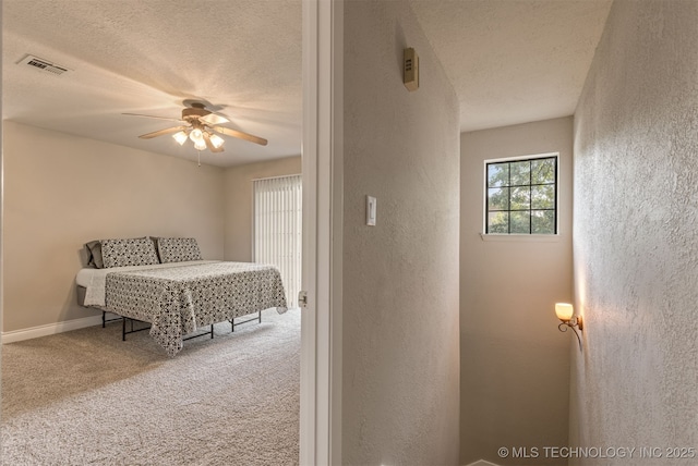 6376 S 80th E Ave Unit 41H, Tulsa, OK 74133 - bedroom with a textured wall, a textured ceiling, carpet floors, and ceiling fan