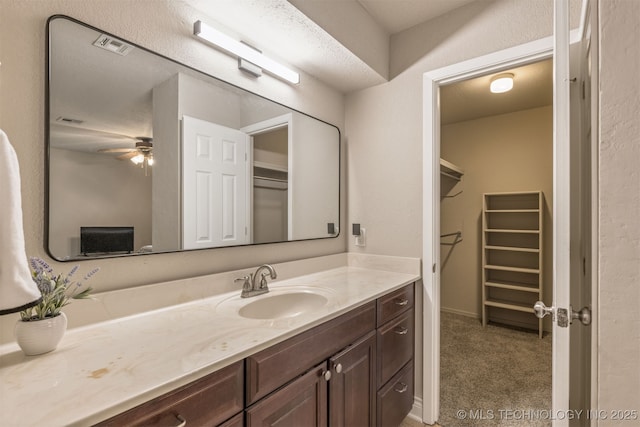 6376 S 80th E Ave Unit 41H, Tulsa, OK 74133 - bathroom with vanity, a spacious closet, and ceiling fan
