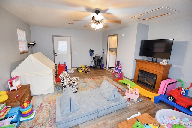 18185 Hilltop Cir, Tahlequah, OK 74464 - rec room with a ceiling fan, washer / dryer, wood finished floors, a glass covered fireplace, and attic access