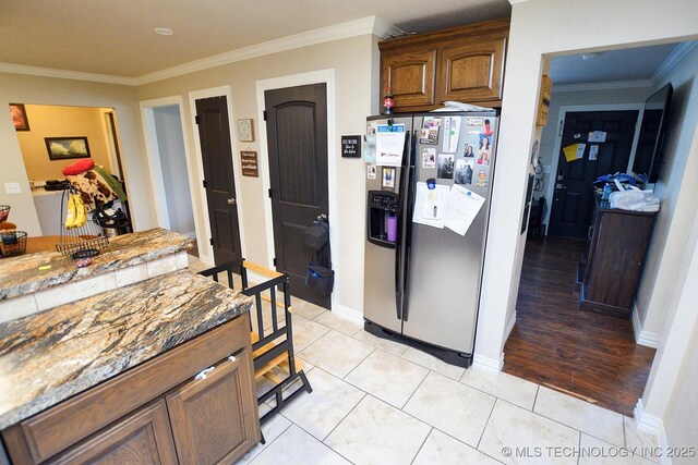 21887 Coffee Hollow Rd, Tahlequah, OK 74464 - kitchen with stainless steel refrigerator with ice dispenser, crown molding, light stone counters, and light tile patterned floors