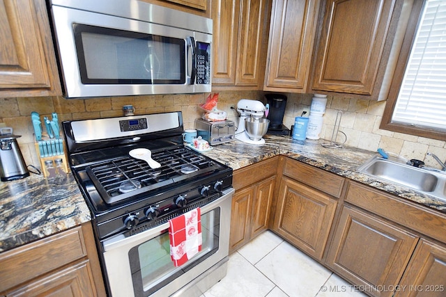 21887 Coffee Hollow Rd, Tahlequah, OK 74464 - kitchen with appliances with stainless steel finishes, decorative backsplash, and brown cabinetry