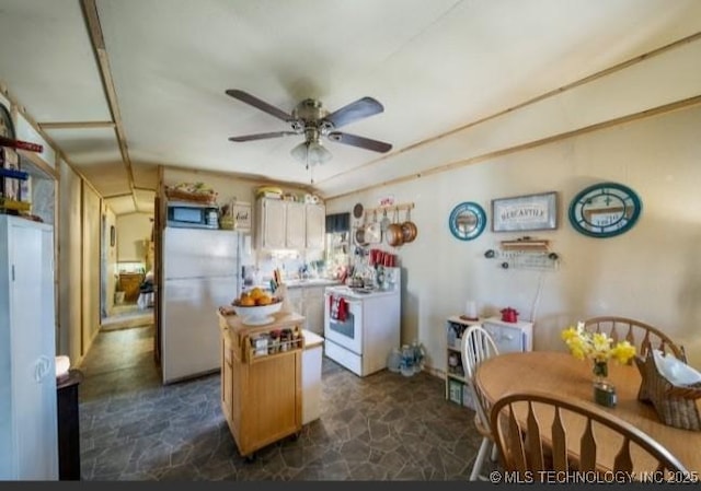 8420 S 145th W Ave, Sapulpa, OK 74066 - kitchen with white appliances, dark stone finish flooring, a ceiling fan, and a center island