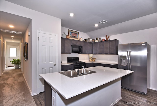 606 Georgia Pl, Muskogee, OK 74403 - kitchen with black appliances, dark brown cabinets, light countertops, a kitchen island with sink, and dark wood-type flooring