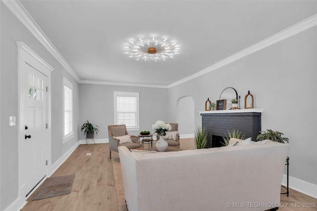 408 K SW, Ardmore, OK 73401 - living room with crown molding, light wood-style floors, a fireplace, and arched walkways