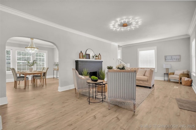 408 K SW, Ardmore, OK 73401 - living room with a chandelier, arched walkways, crown molding, wood finished floors, and a brick fireplace