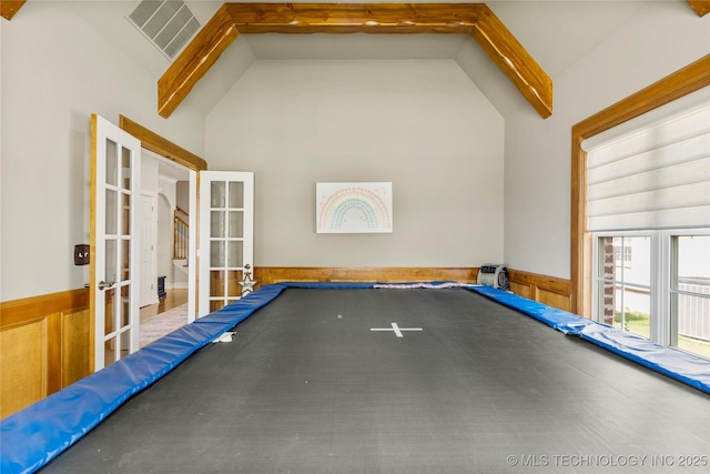 8811 E 110th St S, Bixby, OK 74133 - game room with french doors, wainscoting, high vaulted ceiling, and beam ceiling