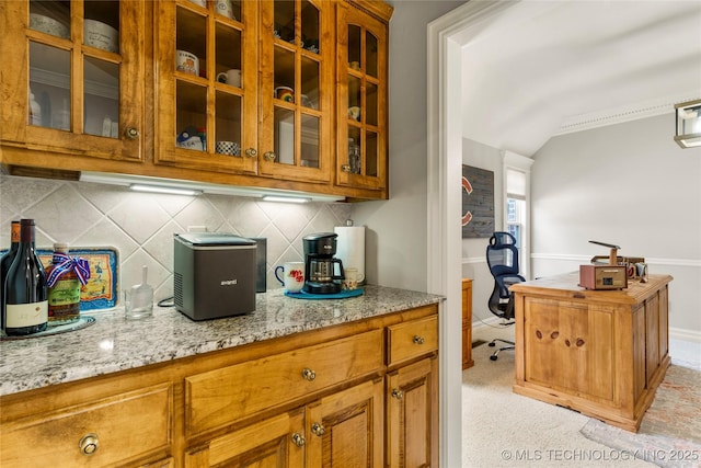 8811 E 110th St S, Bixby, OK 74133 - kitchen with glass insert cabinets, lofted ceiling, light stone counters, backsplash, and an office area