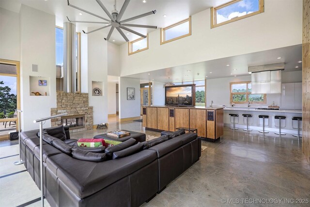 421403 E 1920th Rd, Antlers, OK 74523 - living area featuring a high ceiling, a ceiling fan, a stone fireplace, and concrete floors