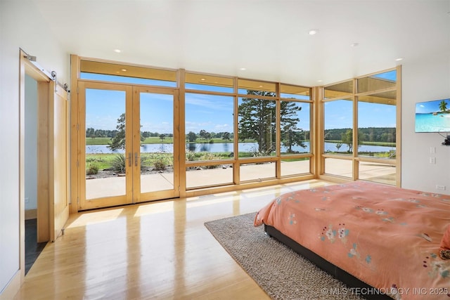 421403 E 1920th Rd, Antlers, OK 74523 - bedroom with expansive windows, access to outside, wood finished floors, and a water view