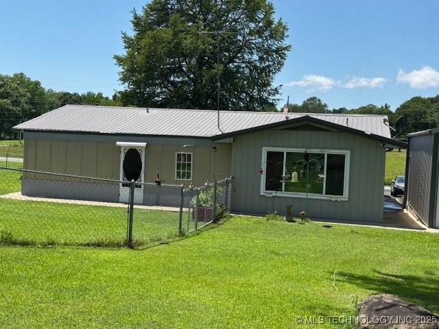 902 NE Rushwood Dr, Stigler, OK 74462 - rear view of house with board and batten siding and a metal roof