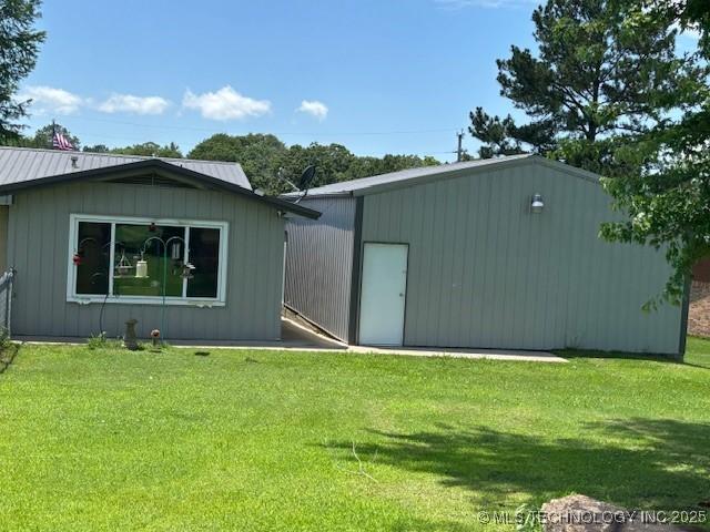 902 NE Rushwood Dr, Stigler, OK 74462 - view of front facade featuring a front lawn, an outdoor structure, and a metal roof